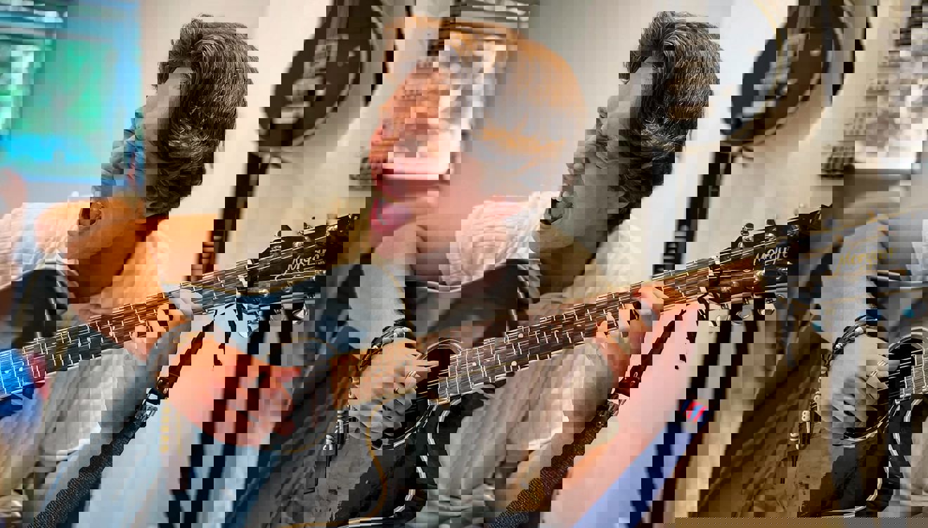 en person som spiller gitar en person som spiller gitar