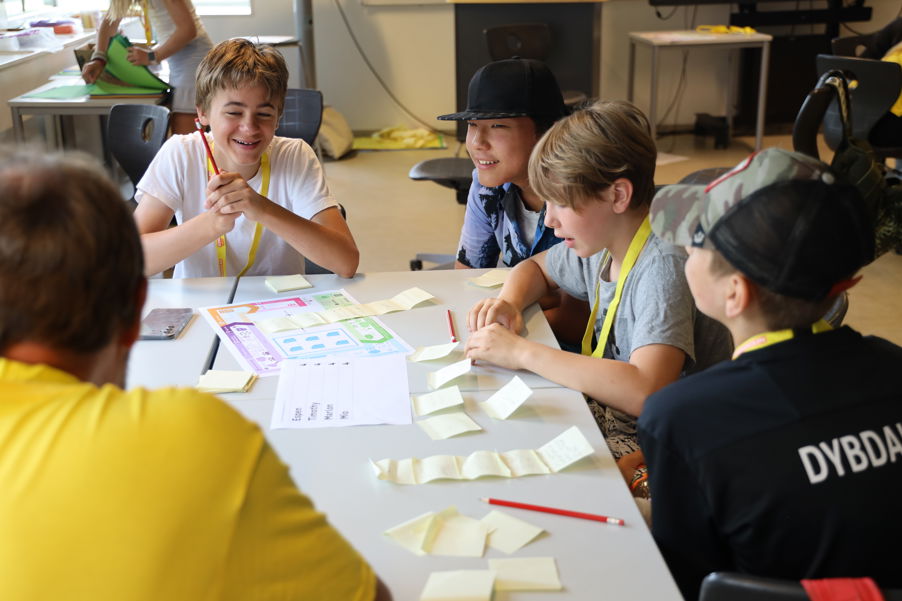 en gruppe mennesker som sitter ved et bord med papirer og penner en gruppe mennesker som sitter ved et bord med papirer og penner